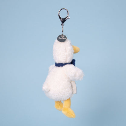 Plush duck keychain with a blue bow tie on a light blue background