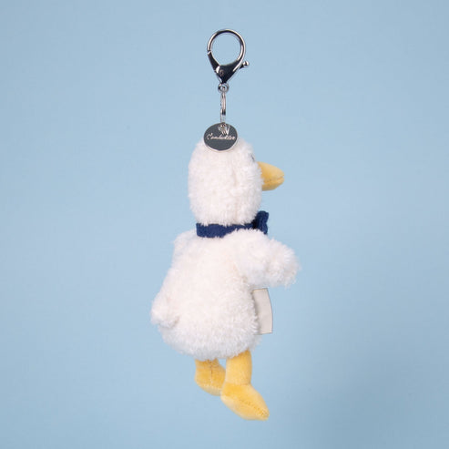 Plush duck keychain with a blue bow tie on a light blue background