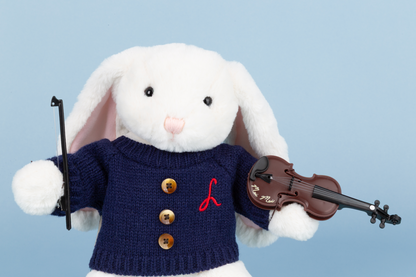 White rabbit plush toy wearing a navy sweater with gold buttons and a red letter 'L', holding a violin.
